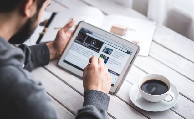 man reading medical news website on tablet